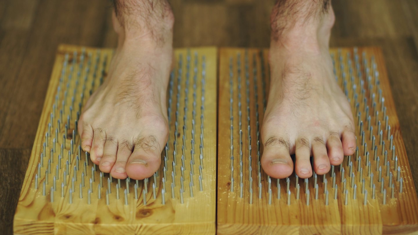 Pieds nus sur deux planches cloutées de clous acérés.